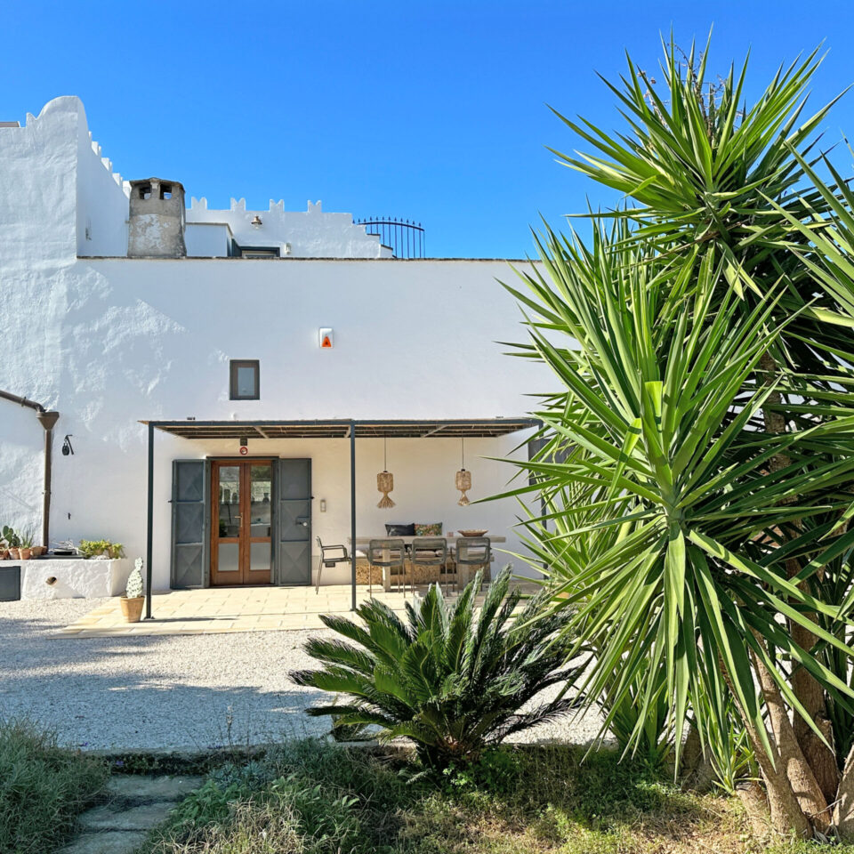 The historic Masseria ai Pini with a tiny tower - view from east side - yocca palms in front reflect the sun