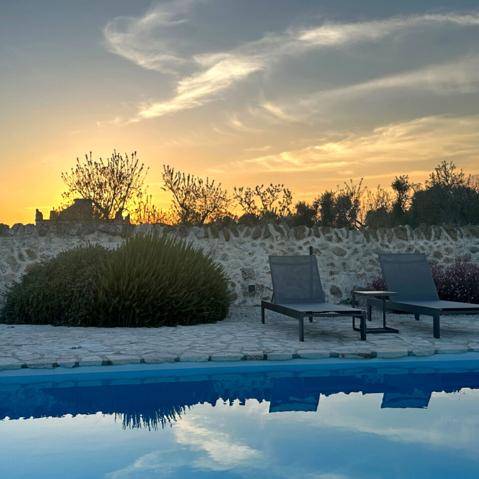 The pool with rosemary, gaura and two sun beds in the sunset